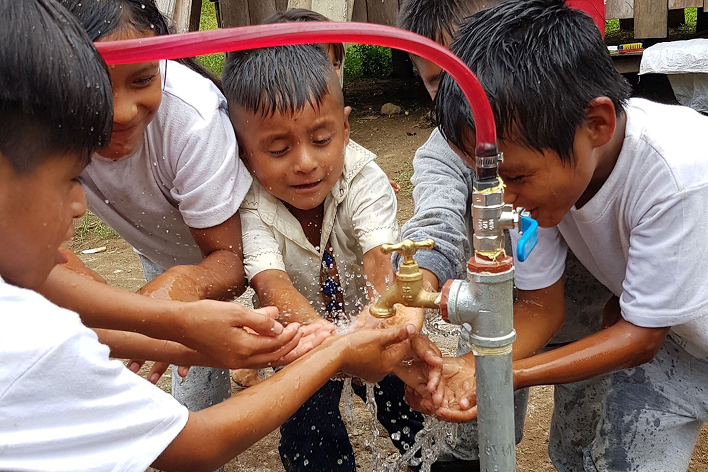 Children gather around water