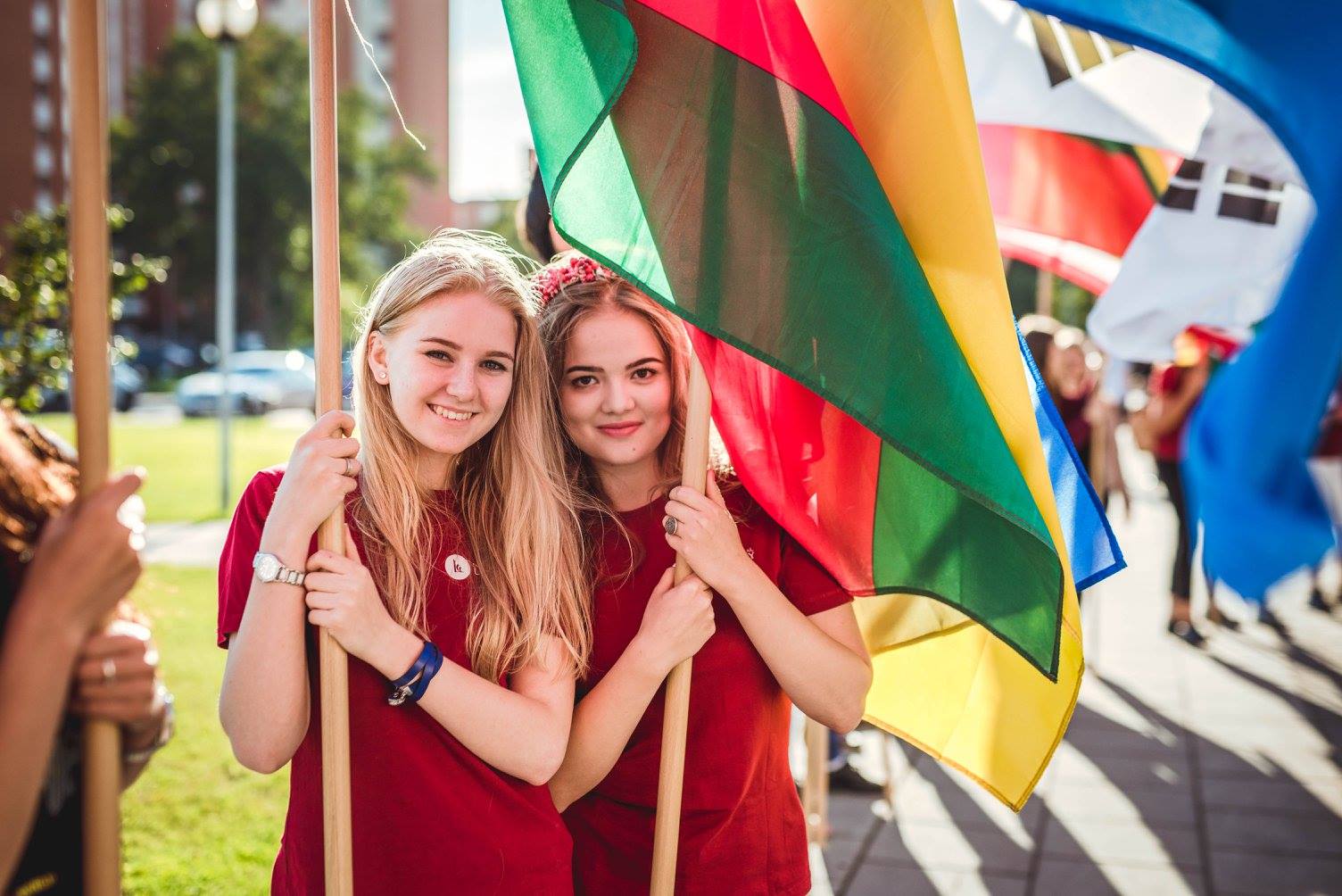 LCC International University Students smile and hold Lithuanian flag