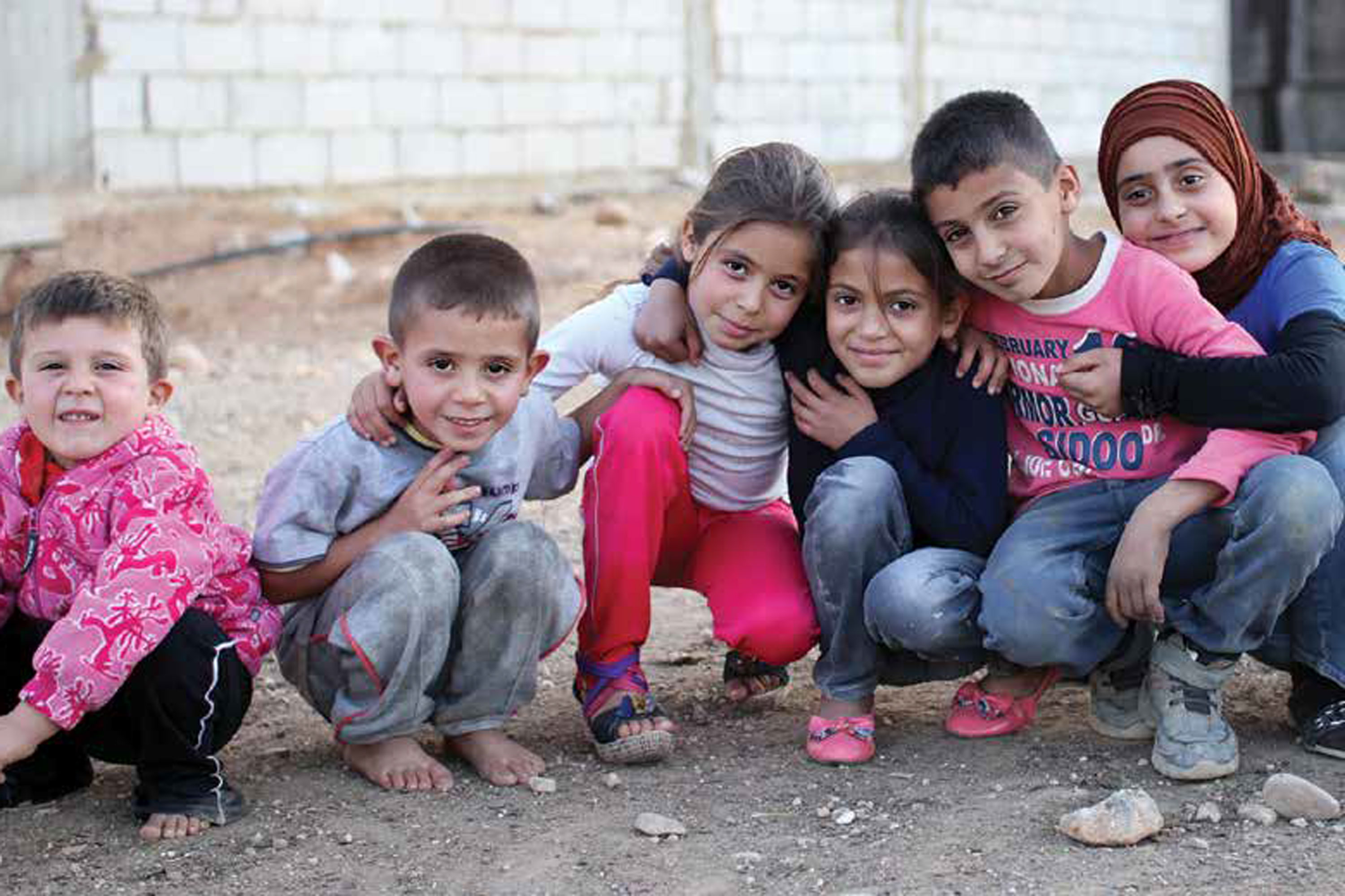 Children gather for a photo and smile