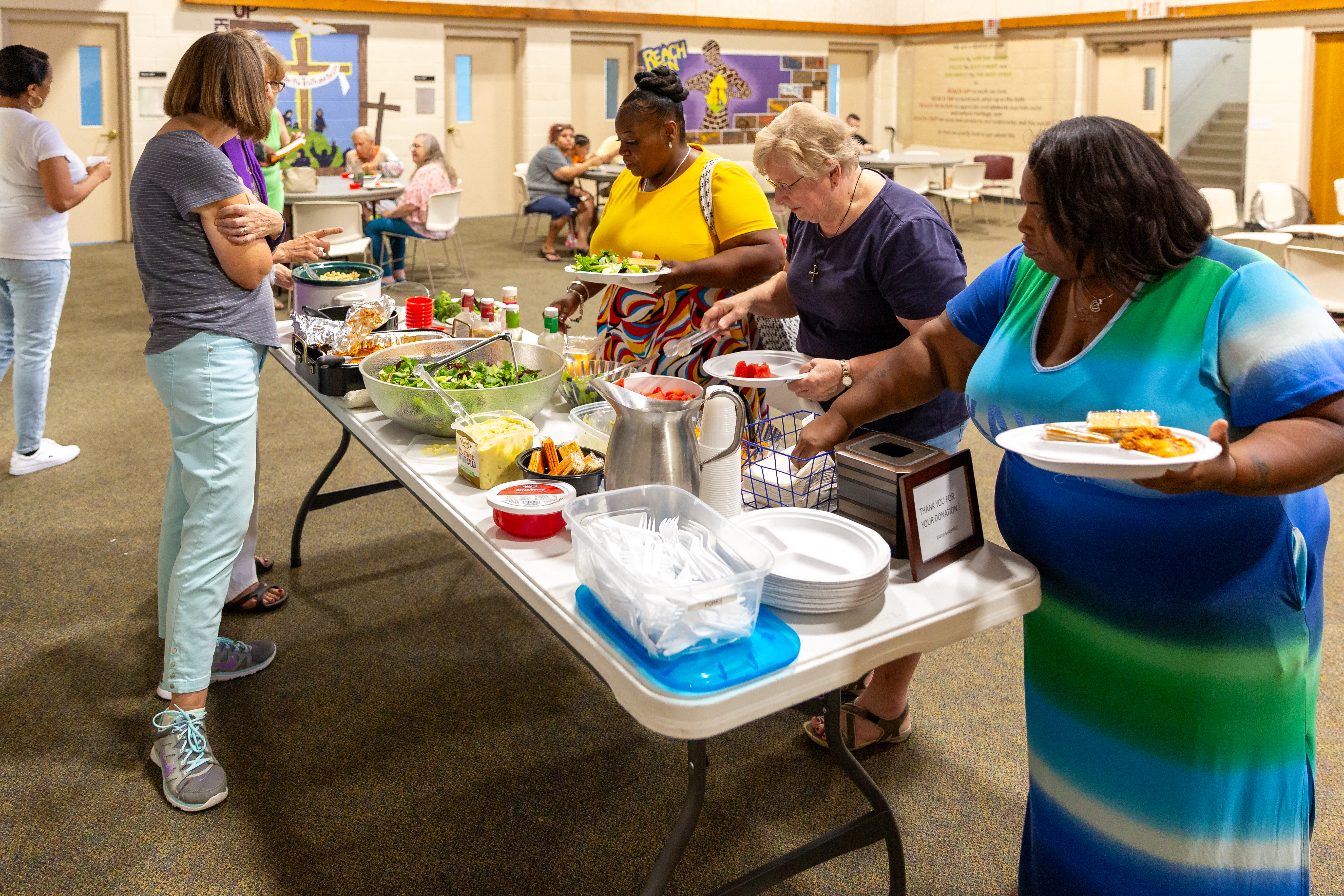 Kavod Fellowship members line up at a table where food is being served