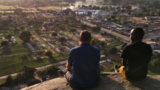 two men sitting looking over a town