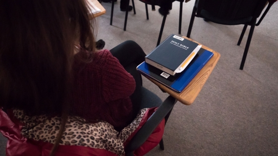 Student in Bible and Theology class with Bible on their desk