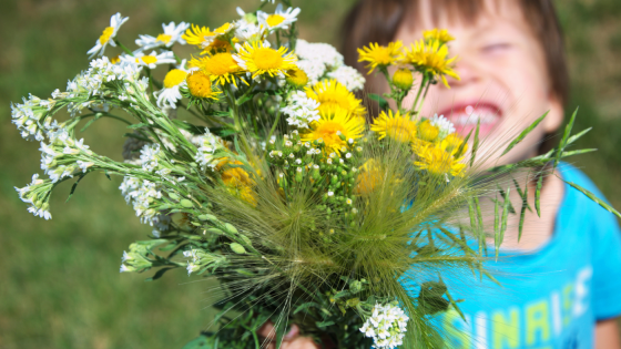Child smiling and holding a bouquet of flowers