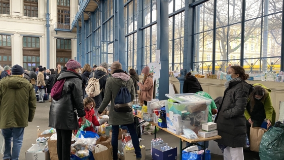 People handing out food and other supplies to refugees