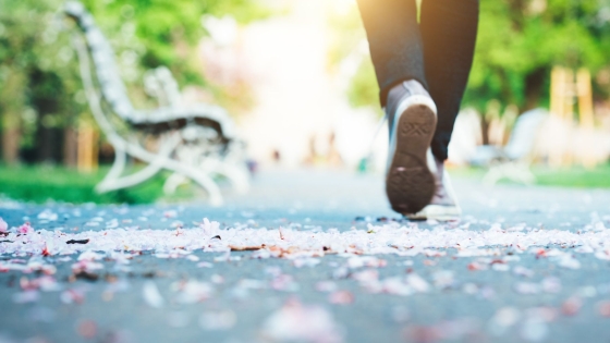 Feet of someone walking on a park path