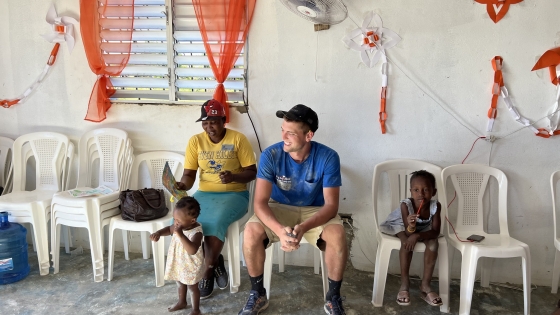 Volunteer sits with a mother and children in the Domincan Republic