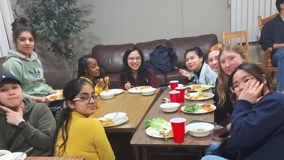 A group of students gather around a table for food