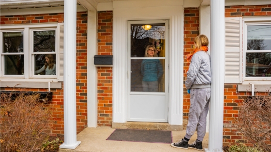 A woman knocks on the door of a neighbor