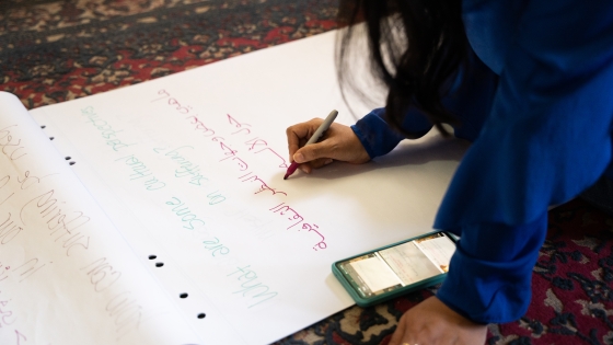 Young woman writing in Arabic on a large notepad