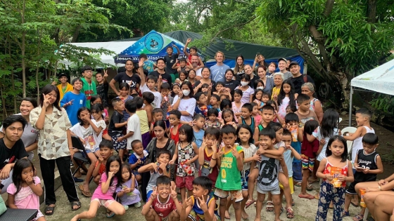 A group of children and young adults pose for a photo