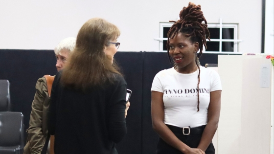 Sesihle talking with a woman wearing an Anno Domini shirt