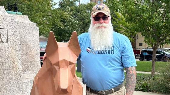 Laszlo stands by the sculpture he created of his service dog, Emperor