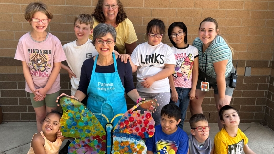 Pamela Alderman and a group of children with a butterfly they created