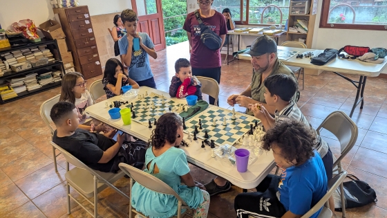 Students gather around chess boards