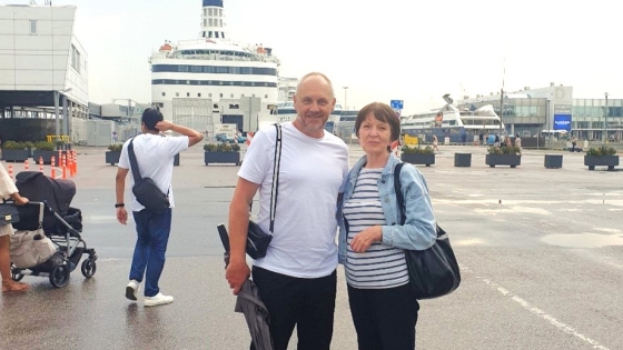 Pastor Pavel and Elena stand in front of the Isabelle cruise ship in an Estonian harbor