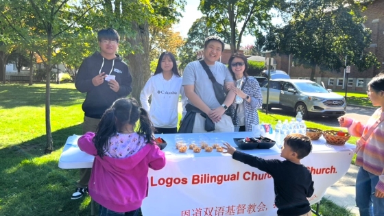 A group of people from Logos stand at a table at a community event