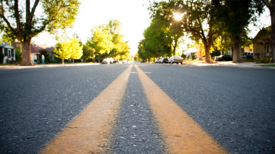 Yellow-painted lanes on a road in a neighborhood at sunrise