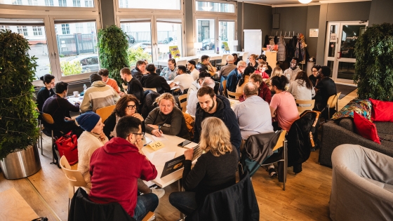 People from diverse cultures and backgrounds gather around tables at the Langauge Cafe in Berlin, Germany