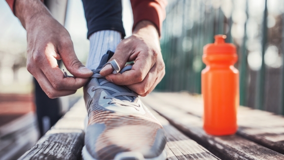 Close up of someone lacing their shoe on a bleacher