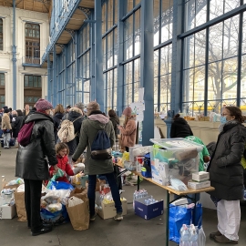 People handing out food and other supplies to refugees