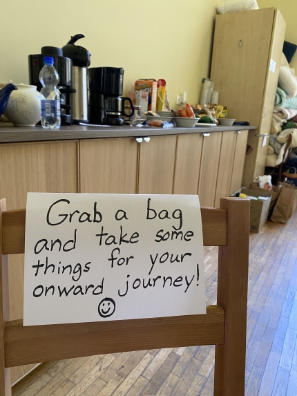 A sign welcoming refugees to take food and other necessities for them as they move onward in their journey
