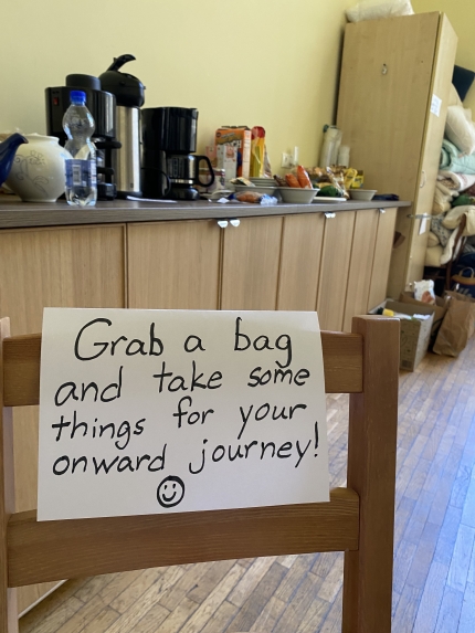 A sign welcoming refugees to take food and other necessities for them as they move onward in their journey