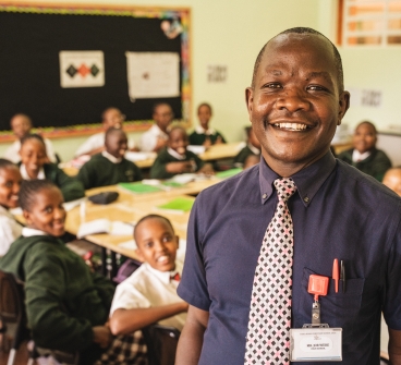 Job Were and his students smiling in their classroom