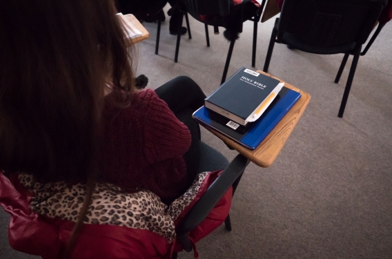 Student in Bible and Theology class with Bible on their desk