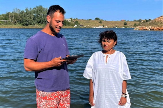 Felipe and Lucretia standing in a lake at Lucretia's baptism