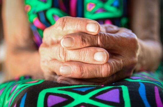 Hands folded in lap in prayer