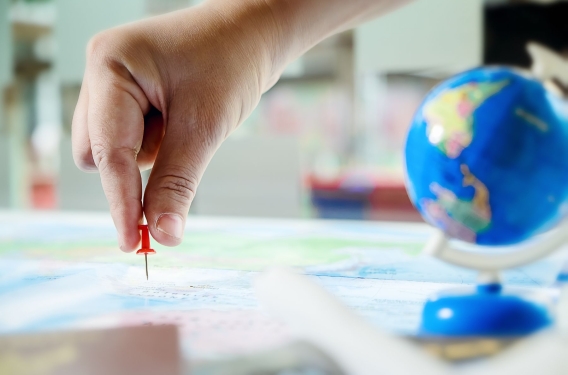 Map and Globe Hand placing a pin in a map